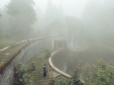 Aerial view of the brutalist Korcanica Memorial Zone monument shrouded in thick fog in the Grmec mountain forest Sanski Most, Federation of Bosnia, Bosnia and Herzegovina.