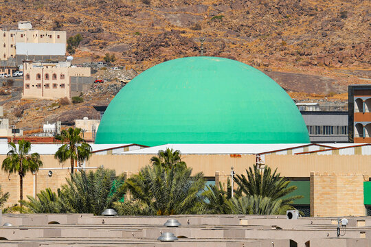 Huge green dome of King Fahd Grand Mosque against rocky mountain in Taif, Saudi Arabia