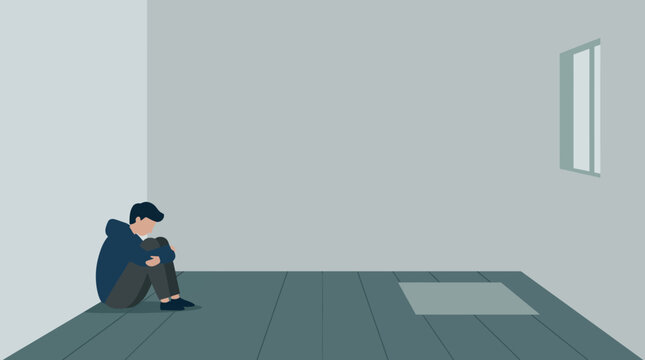 A man sitting alone in an empty room feeling sad and depressed.