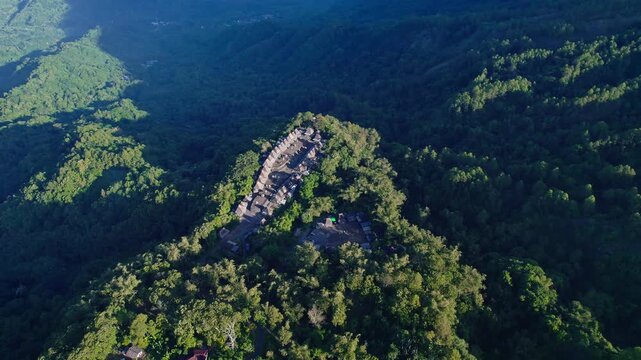 Aerial view of Bena Traditional Village with its iconic thatched roofs nestled on a lush green ridge in Kecamatan Jerebuu, Nusa Tenggara Timur, Indonesia.