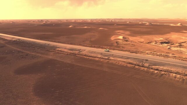 Aerial Shot of Car Driving on Highway Through Yardang Landform in Qinghai, China