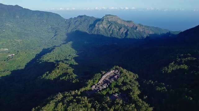 Aerial view of Bena Traditional Village with its iconic thatched roofs nestled on a lush mountain ridge in Kecamatan Jerebuu, Nusa Tenggara Timur, Indonesia.