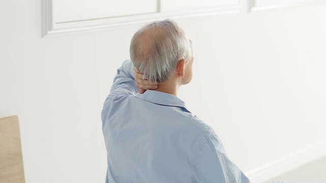 頭を押さえる体調不良の高齢者の男性