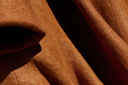 Textural linen fabric with a rolled sleeve cuff and deep pocket, showing organic weave and tactile grain for sustainable fashion branding