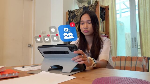 A young Southeast Asian student scrolls through her tablet network, featuring a 3D tracked social communication badge showing people chatting, surrounded by virtual love hearts, mail envelopes, and ch