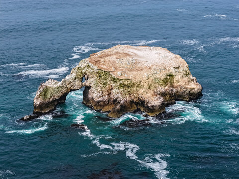 Turtle-shaped rocky islet in Marcona, Ica, with blue sea and natural arch