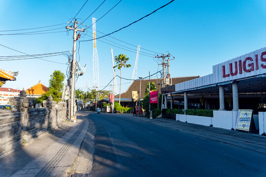 Canggu, Bali, Indonesia, June 17, 2026: Asphalt street view featuring Luigis restaurant and Deus Ex Machina shop under a bright blue sky in Canggu, Bali, Indonesia.
