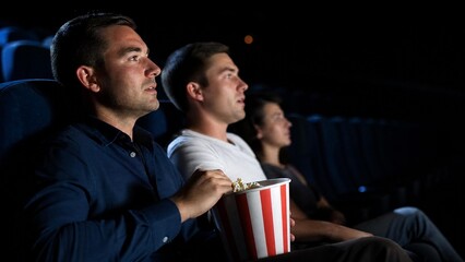 Obraz premium Young People Watching Movie in Cinema Theater Eating Popcorn
