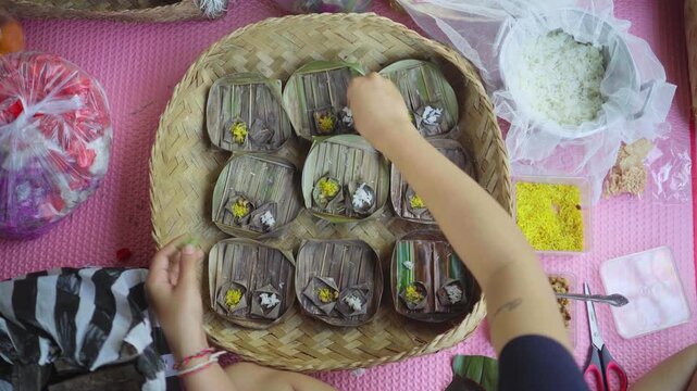 a Balinese Woman is doing preparation of Banten or Canang, a Balinese Hindu offerings, daily spiritual and cultural craft made from palm leaf. 4K horizontal footage