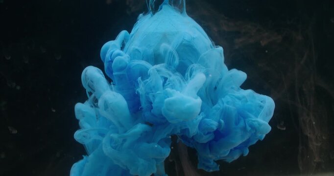 Fume drop. Paint blob water. Blue dye spreading on glass diamond brown sphere. Art fog color blur splash on black background free space.