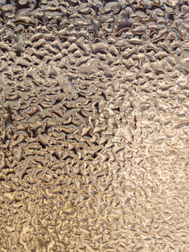 full-frame abstract pattern of natural water condensation droplets on a transparent surface, ideal for cold temperature, moisture, weather, or refreshing liquid texture concepts.