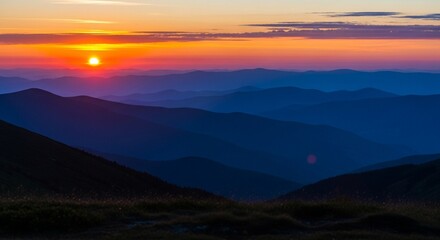 Obraz premium Majestic Sunset Behind Distant Blue Mountain Ridges