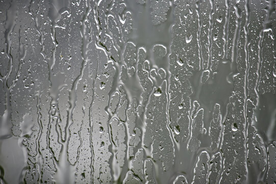 Rain Streaks And Water Droplets On A Window Glass With Moody Gray Condensation Texture