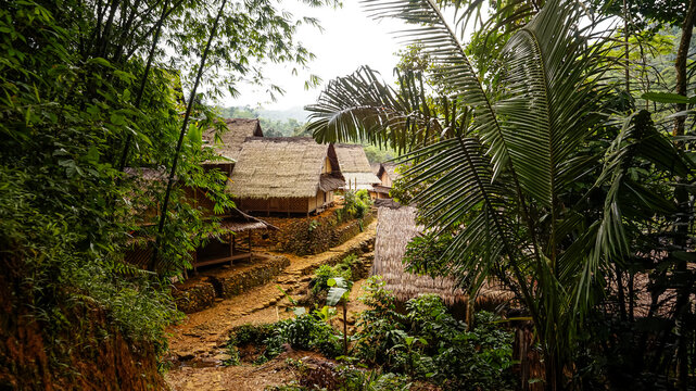 Traditional wooden village houses with natural dirt pathways in the rural landscape of Baduy Luar, Banten, Indonesia
