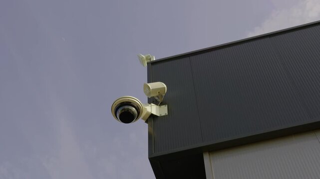 CCTV security camera mounted on a modern industrial building exterior, monitoring property, safety, surveillance, and protection.