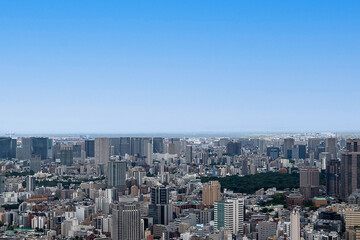 青空の下、東京湾へと広がる高層ビル群の東京都市景観を見渡す眺め © yoshi