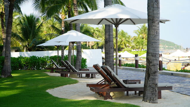 A lounge chair on the beach at a resort hotel, vacation and travel