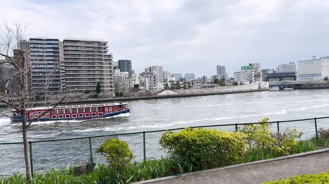 Sightseeing Boat Navigating the Sumida River with Tokyo Cityscape Background