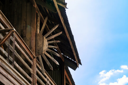 Old traditional wooden house balcony featuring unique sunburst wood carving decoration and designed to prevent people from climbing over balcony. Sunburst design by wood craft. Traditional lifestyle
