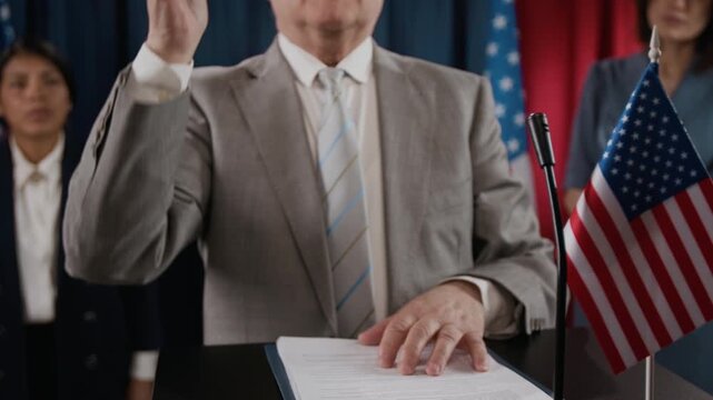 Portrait of senior politician speaking at podium with American flag and gesturing during press conference. Clip is ideal for political campaigns, news broadcasts, and government videos, close up shot