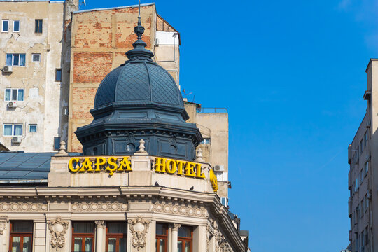 Historic Capsa Hotel building with ornate dome and classical architectural details under a clear blue sky. Bucuresti, Romania - March 15 2026
