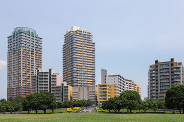 Obraz premium 広い芝生の公園と高層タワーマンション群の風景 
