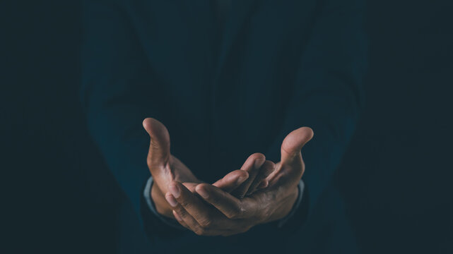 Two open hands cupped together against a dark background, symbolizing offering, help, or receiving.