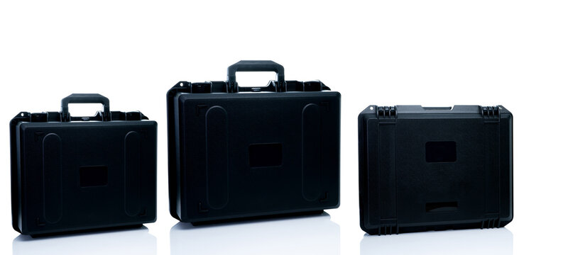 New toolbox or plastic case isolated on white background. Empty hard plastic suitcase with handle. Set of black plastic travel luggage. Modern case for toolkit, drone storage. Black new tool box.