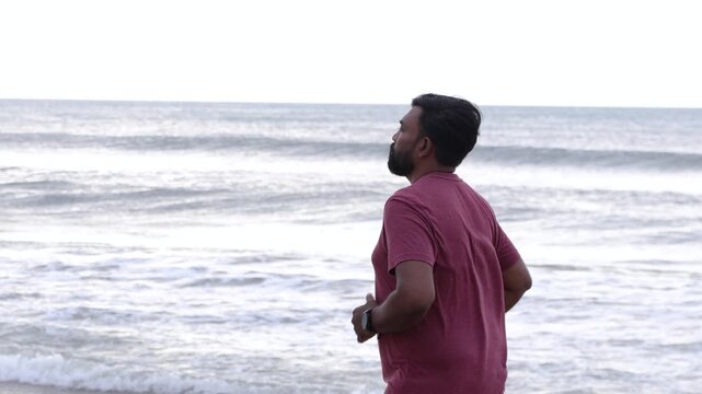 Bearded Man Jogging on Beach with Yellow Water Bottle for Summer Fitness and Hydration Lifestyle
