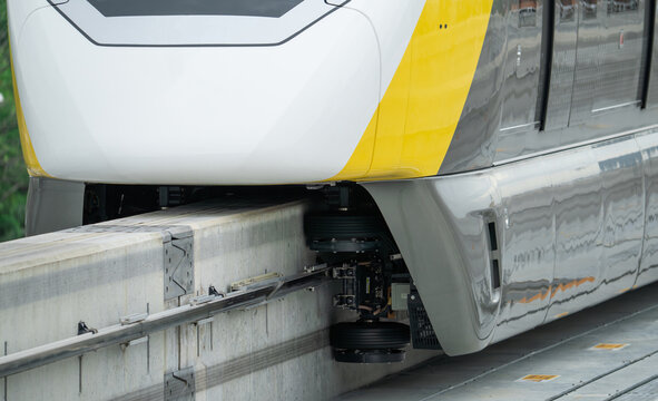 Elevated monorail train on rail. Guide wheels rubber tire on concrete guideway beam with conductor rail. Monorail technology. Modern mass transit. Rail transportation. Driverless straddle monorail.