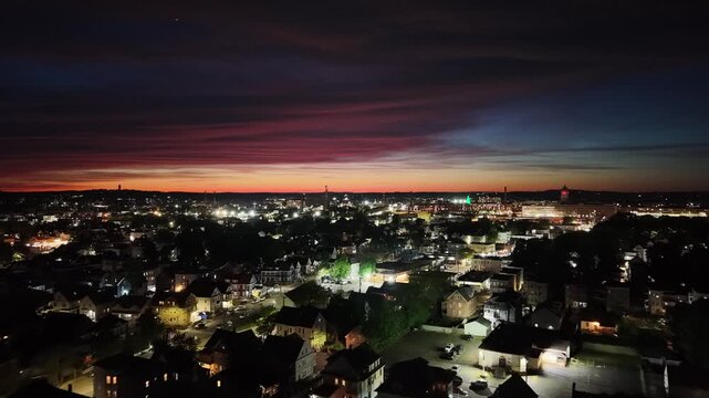 Aerial view of Lawrence, Massachusetts at night featuring glowing city street lights and residential neighborhoods under a dark evening sky