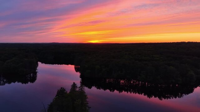 Backward high angle drone view during a stunning sunset at Harold Parker State Forest in Massachusetts, United States