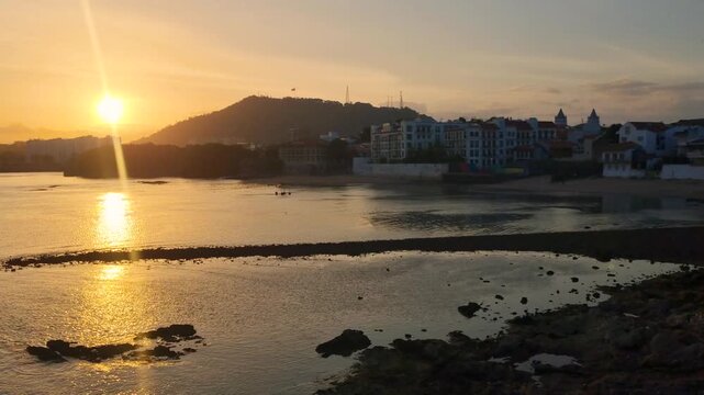 Sunset view from Plaza de Francia in Panama City&rsquo;s Casco Viejo, with warm light reflecting on the Pacific Ocean as the city fades into deep evening shadows, creating a calm atmospheric skyline scene