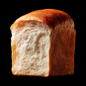 Half loaf of soft milk bread shokupan isolated on black background with clipping path, concept of bakery freshness qualities