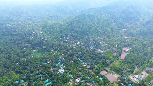 Aerial view of lush green hills and scattered village houses nestled among dense tropical vegetation in Cox's Bazar, Chittagong Division, Bangladesh.