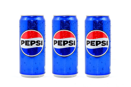 Three Pepsi blue aluminum cans featuring the classic logo are covered in refreshing condensation droplets and arranged in a row to showcase a popular carbonated soft drink product professional shot