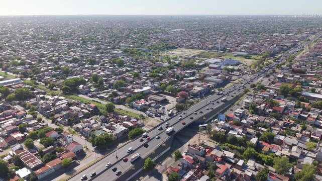 Autopista transitada durante un d&iacute;a soleado en medio de un barrio residencial, movilidad urbana, transporte terrestre, infraestructura vial, conexi&oacute;n metropolitana y vida cotidiana