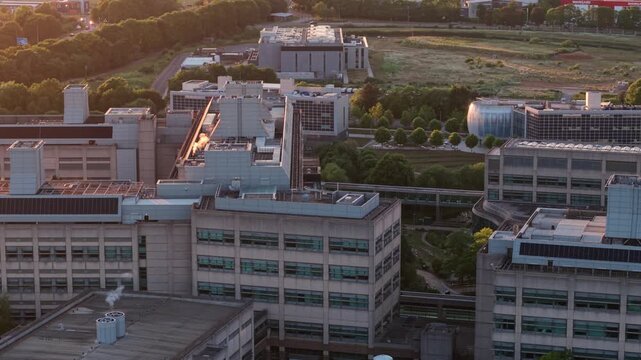 Aerial view of the GSK Stevenage research and development campus with modern laboratory buildings and green surroundings during golden hour in Stevenage, England, United Kingdom.