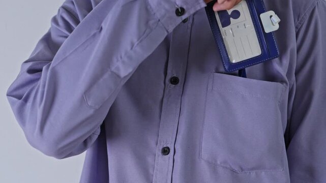 Close-up view of Office worker taking blue ID badge template out of his shirt pocket