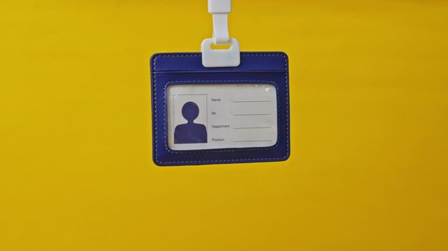 Close-up view of Blue leather ID badge template hanging against bright yellow background