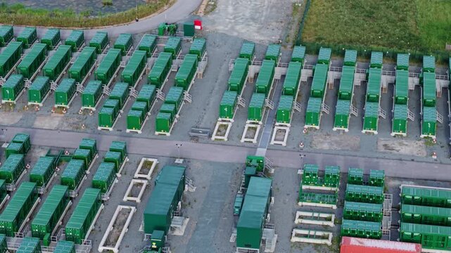 Aerial view of the Tilbury Battery Energy Storage System featuring rows of green container units and industrial infrastructure in Tilbury, England, United Kingdom.