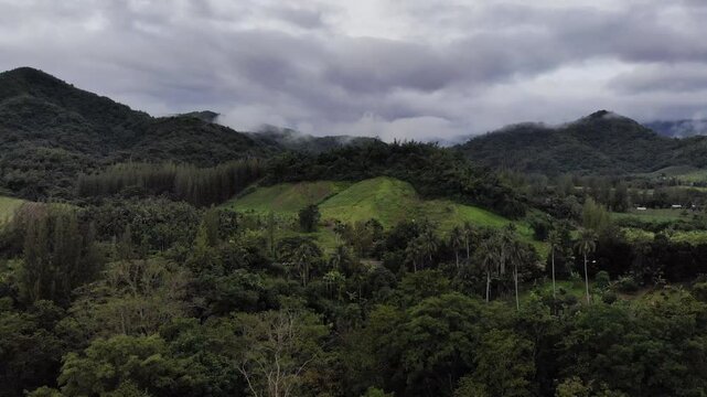 Aerial drone footage of a calm mountains and clouds. Ideal for nature, travel, environment, tropical forest, and cinematic landscape projects.