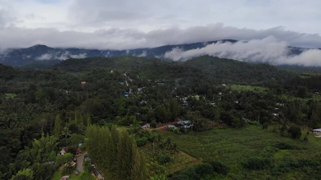 Aerial drone footage of a calm mountains and clouds. Ideal for nature, travel, environment, tropical forest, and cinematic landscape projects.
