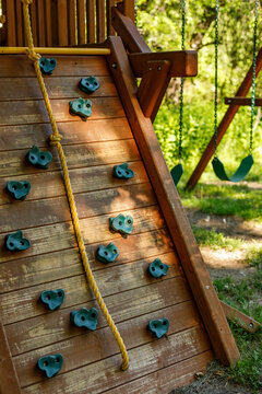 Wooden backyard playset with climbing wall and rope