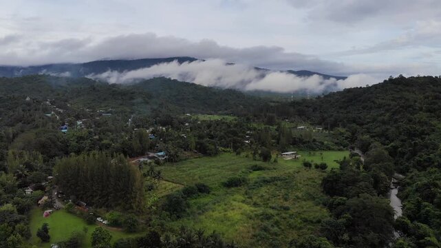 Aerial drone footage of a calm mountains and clouds. Ideal for nature, travel, environment, tropical forest, and cinematic landscape projects.