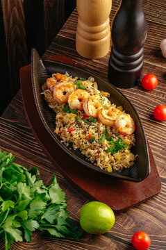 Grilled shrimp and fried rice served on a rustic wood table