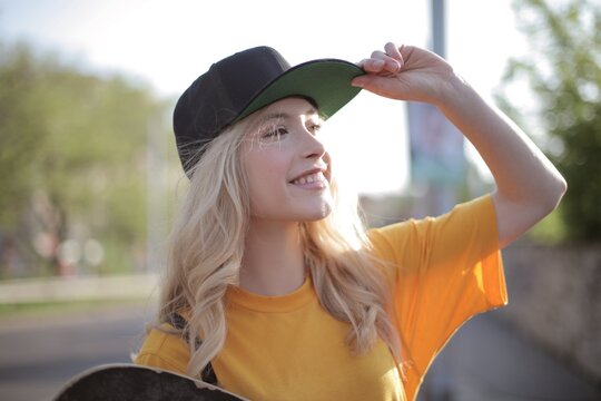 Smiling young woman in a cap enjoying a sunny day