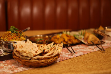 Naklejka na ściany i meble Assorted Traditional Indian Cuisine Spread on a Restaurant Table