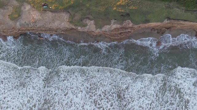 Orilla del mar con olas chocando contra acantilado, naturaleza costera vista cenital a&eacute;rea