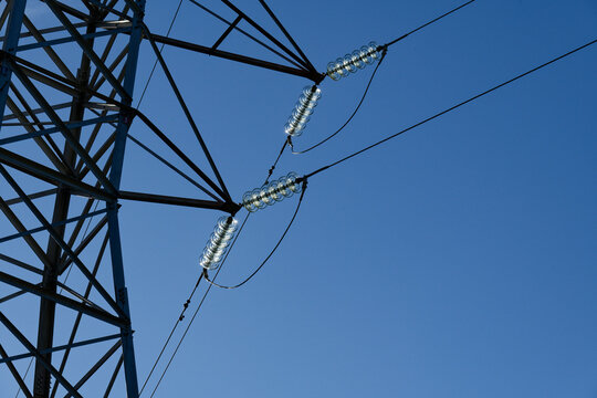 Sunlight catches the glass insulators on a transmission tower